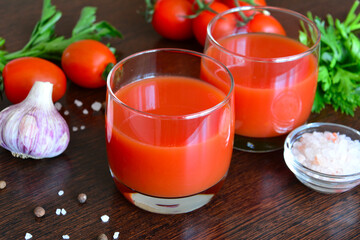 tomato juice in drinking glass with pink salt and parsley, close-up 