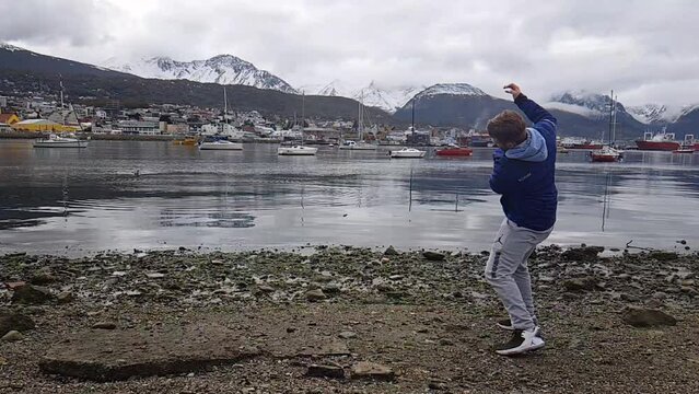Man throwing stone in Ushuaia doing stone skipping