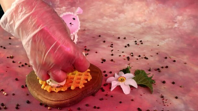 Chef hands putting slice of mozzarella, tomato and parsley over liege waffles and made sandwich.