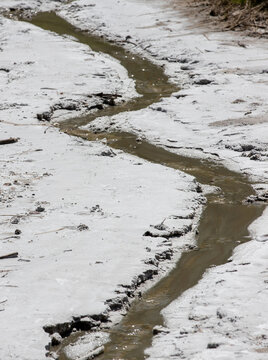 a stream of salt water meandering on the ground with crystallized salt