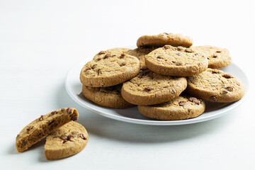 chocolate chip cookies on a white plate. Stack of biscuits on the white table. copy space