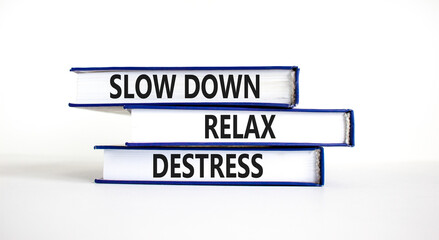 Destress symbol. Concept words Slow down Relax Destress on books. Beautiful white table white background. Psychological business slow down Relax destress concept. Copy space.