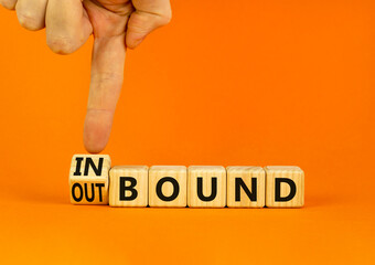 Inbound or outbound symbol. Businessman turns wooden cubes and changes the concept word Outbound to Inbound. Beautiful orange table orange background. Business inbound or outbound concept. Copy space.