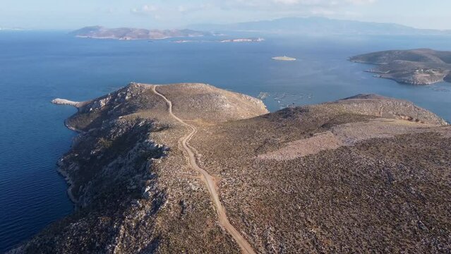 Forward reveal aerial shot of road on Kalymnos island and fish farm in Aegean Sea. Greece.