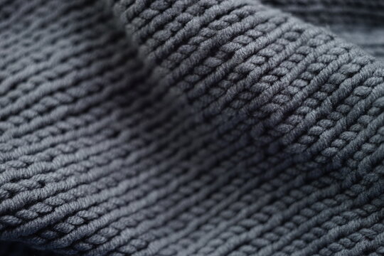 Knitted grey background, gray scarf cozy pattern