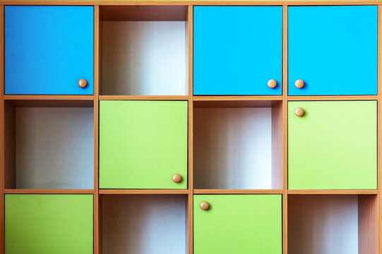 Multi colored wooden cabinet compartmentalize on cells with empty shelves front view