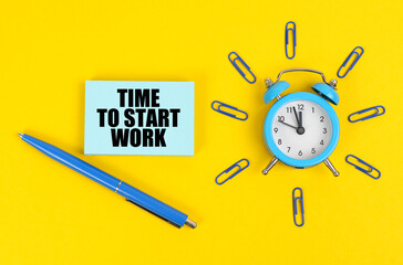 On the yellow surface there is an alarm clock, a pen and stickers with the inscription - Time to...