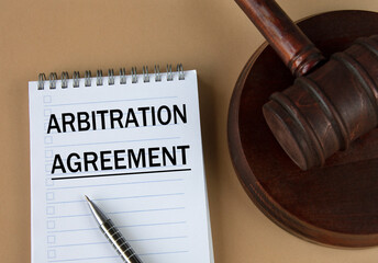ARBITRATION AGREEMENT - words in white notebook on the background of the judge's hammer with stand - obrazy, fototapety, plakaty