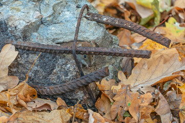 Tiny fieldmouse sits on the man-made concrete stone with metallic armature