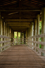 Wooden structure, with bridge, that passes over a lake. 