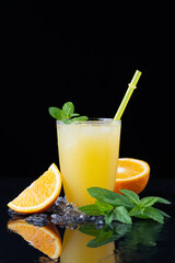 A glass of orange juice on a black background