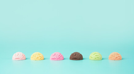 Assortment of various flavor ice cream balls on a light blue background. Summer, refreshment minimal concept.