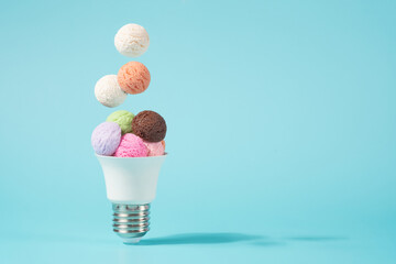 Ice cream balls falling into the light bulb cone. Electricity shortage minimal concept. - obrazy, fototapety, plakaty