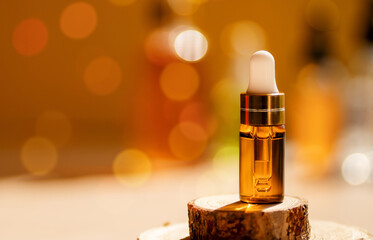 Cosmetic glass dropper bottle on wooden podium with oil, serum or fruit peeling in the sunlight....