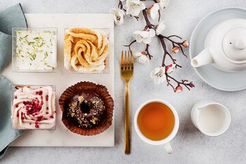 Drinking afternoon tea with sweet desserts. Plate with different pieces of cakes on table. Pastry, bakery, confectionery concept - obrazy, fototapety, plakaty