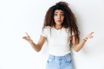 Portrait of surprised shocked terrific young lady with eyes popped out, notices something terrible in front, spreading hands at camera, posing isolated at white background. People emotions concept