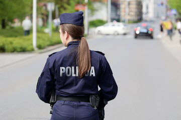 Policjantka w niebieskim mundurze podczas pracy w mieście. - obrazy, fototapety, plakaty