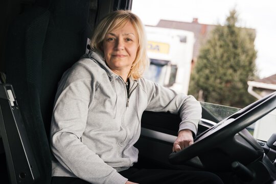 Caucasian mid age woman driving truck. trucker female worker, transport industry occupation 