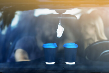 two cups of coffee or tea on car roof on couple background outdoors. mockup. romantic date with hot drink take away.