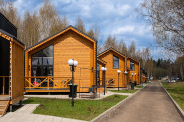 A group of houses in the same style. Trendy modern barnhouse style houses. bright blue sky