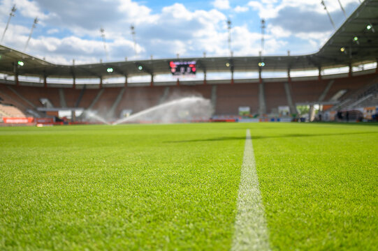 Grass on the soccer pitch at the stadium and watering in the backgraound