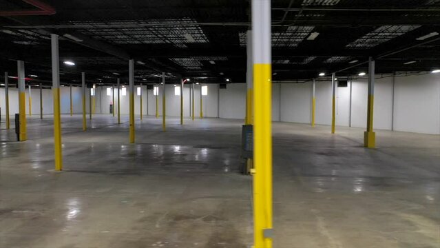Slider Shot View of the Inside of a Large, Dark Commercial Warehouse