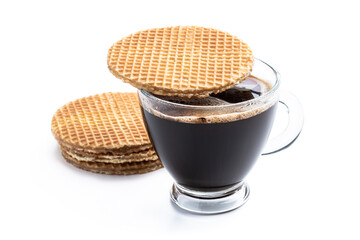 Melted Dutch caramel waffle on cup of coffee isolated on white