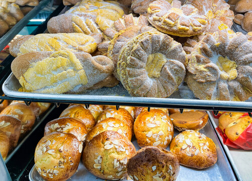 View of Mexican pan fino and picones on baking trays at a bakery. Mexican sweet bread.