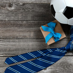 Fathers Day holiday appreciation with knotted tie, giftbox and soccer ball