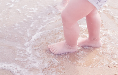 Fototapeta premium Low angle view of a child walking along the sea coast