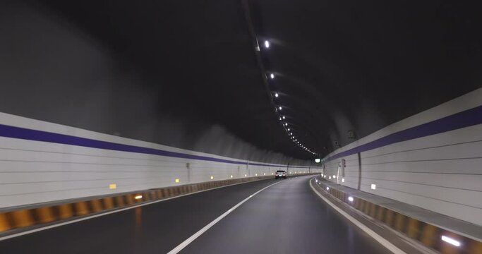 Driving car in a tunnel. Words in the footage means speed limitation at 80km per hour, the tunnel's name 