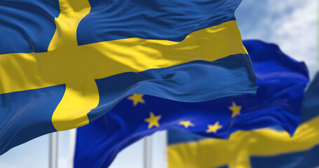 Detail of the national flag of Sweden waving in the wind with blurred european union flag in the...
