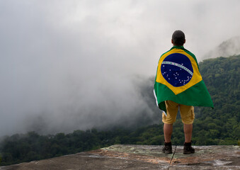 Young Man at Mountain Looking to Horizon in Nature with brazilian Flag.