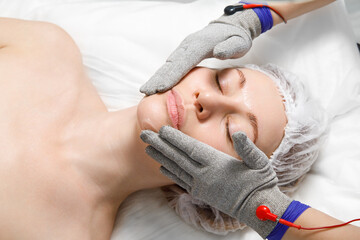 A woman undergoes a facial rejuvenation procedure in a cosmetology clinic. Getting facial hydro...