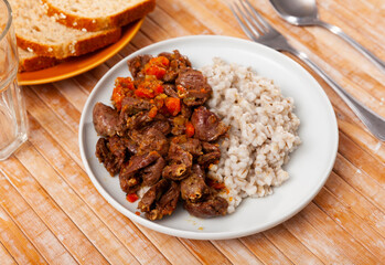 Barley with chicken hearts on a plate