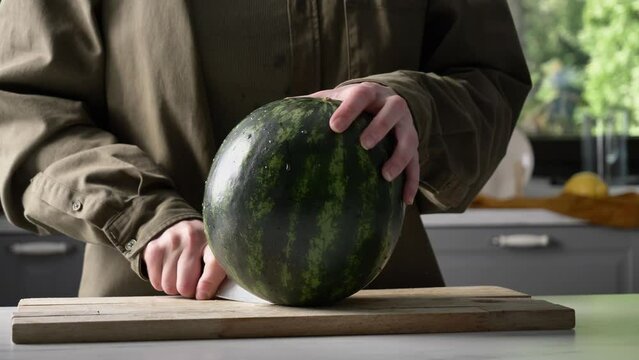 Man cut watermelon on desk on kitchen