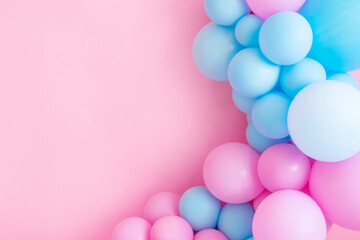 Fototapeta na wymiar Blue and pink balloons on a pink background with copy space.