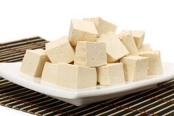 Tofu cubes on plate isolated on white background