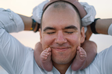 Fototapeta premium Happy Father's day. Father and baby play on the beach. Dad and him Child together enjoying sunset. Loving single father hugs cute little son.