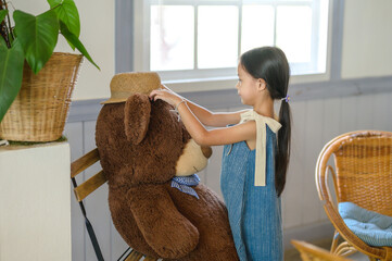 Girl alone happy and enjoy travel in my house with big teddy bear.