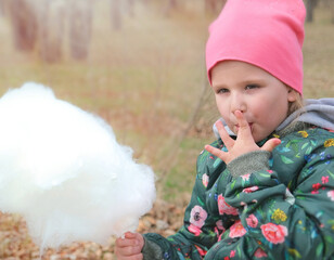 Child girl eating cotton candy