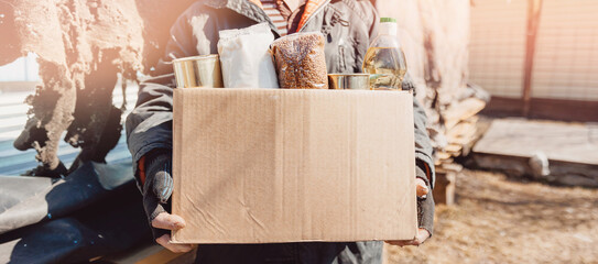 Concept banner humanitarian aid to refugees. Old man senior is holding cardboard box of donations...