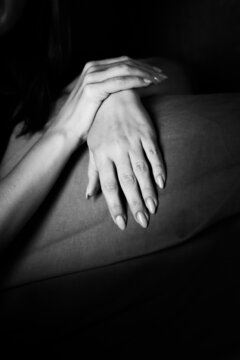 Young, well-groomed women's hands in a black and white photo. Vertical photo.