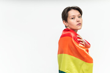 middle waist portrait of a gay woman dressed with the LGBT icon flag looking at camera in a studio shot. High quality photo