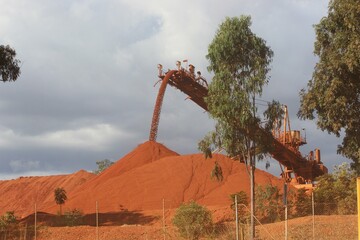 red iron ore falling from a chute in Weipa mine. QLD Australia