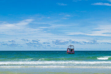Fototapeta premium Fishing boat on the turquoise sea with bright blue sky.