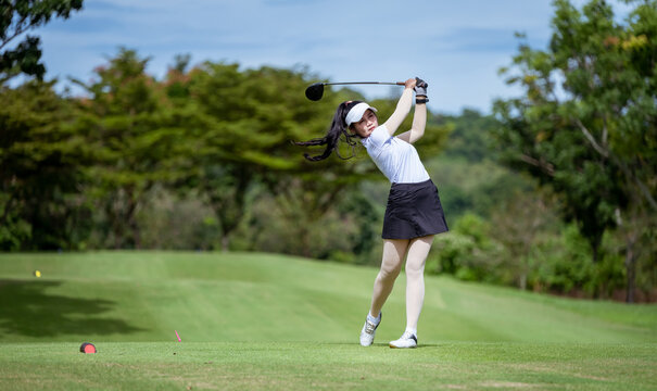 Professional woman golfer teeing golf in golf tournament competition at golf course for winner