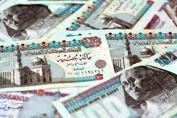 Pile of Egyptian money banknotes of 100 LE, 50 LE, selective focus of a stack of one hundred...