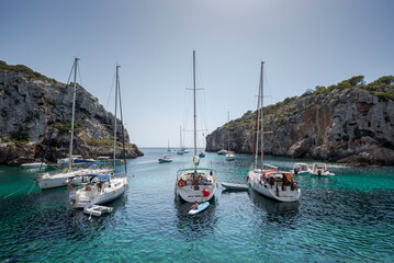 Sailing boats anchored in Cales Coves, a famous cove in the municipality of Alaior, Menorca, Spain
