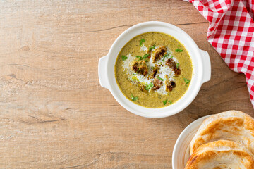 Afghani chicken in green masala curry or Hariyali tikka chicken hara masala with roti or naan bread